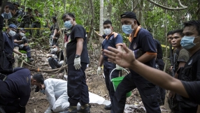 Hundreds of suspected trafficking victims pulled out of shallow graves in Malaysian jungle